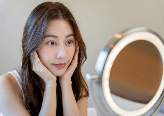 女性が鏡を見ている写真